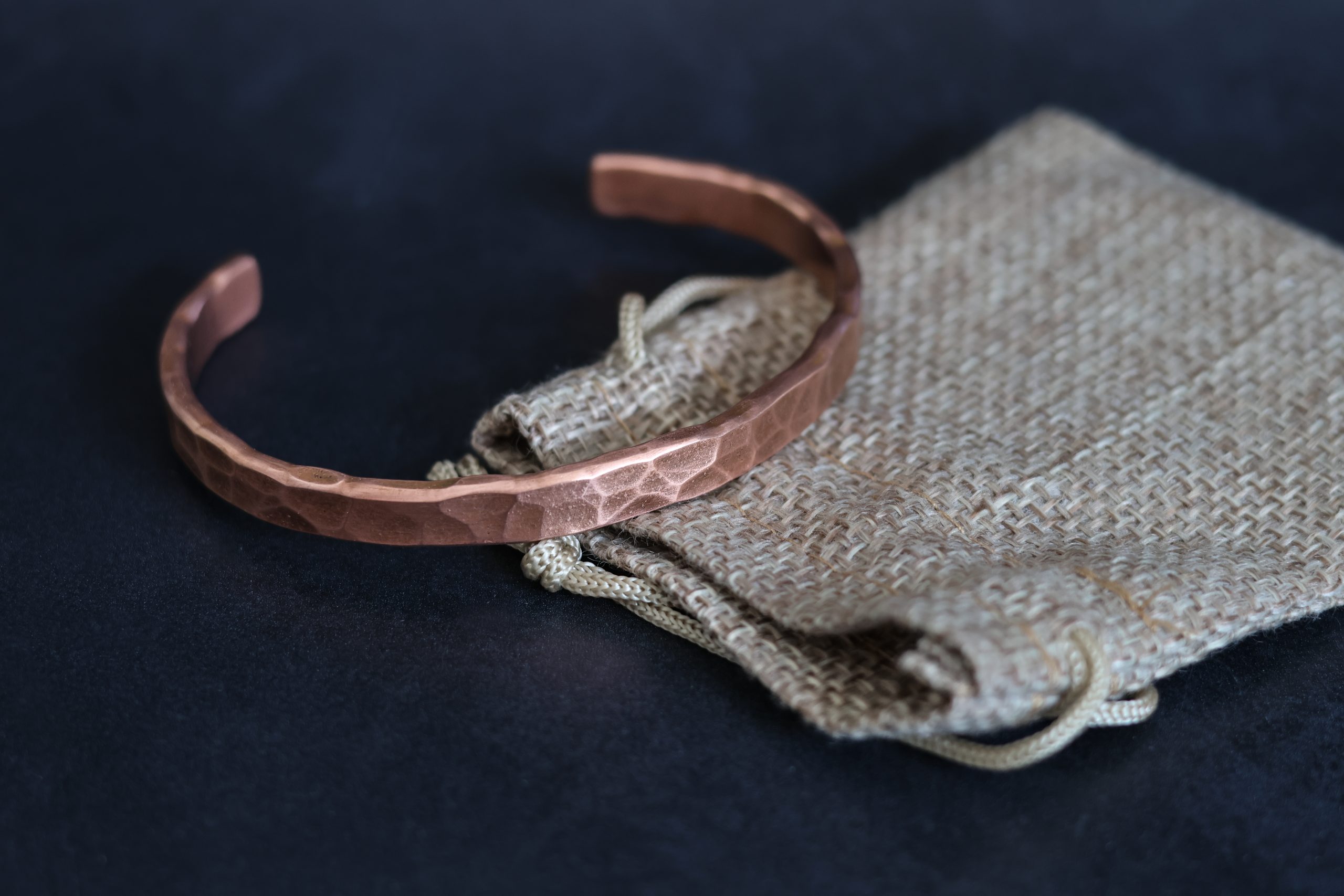 9E2A0177 men's copper bangle which makes a great gift. espically as a copper wedding anniversary gift. The hammered copper bangle comes in a range of sizes. The open cuff bangle is made from solid copper and is handcrafted in Devon, UK by award winning jeweller James French at JWF Unique Designs.