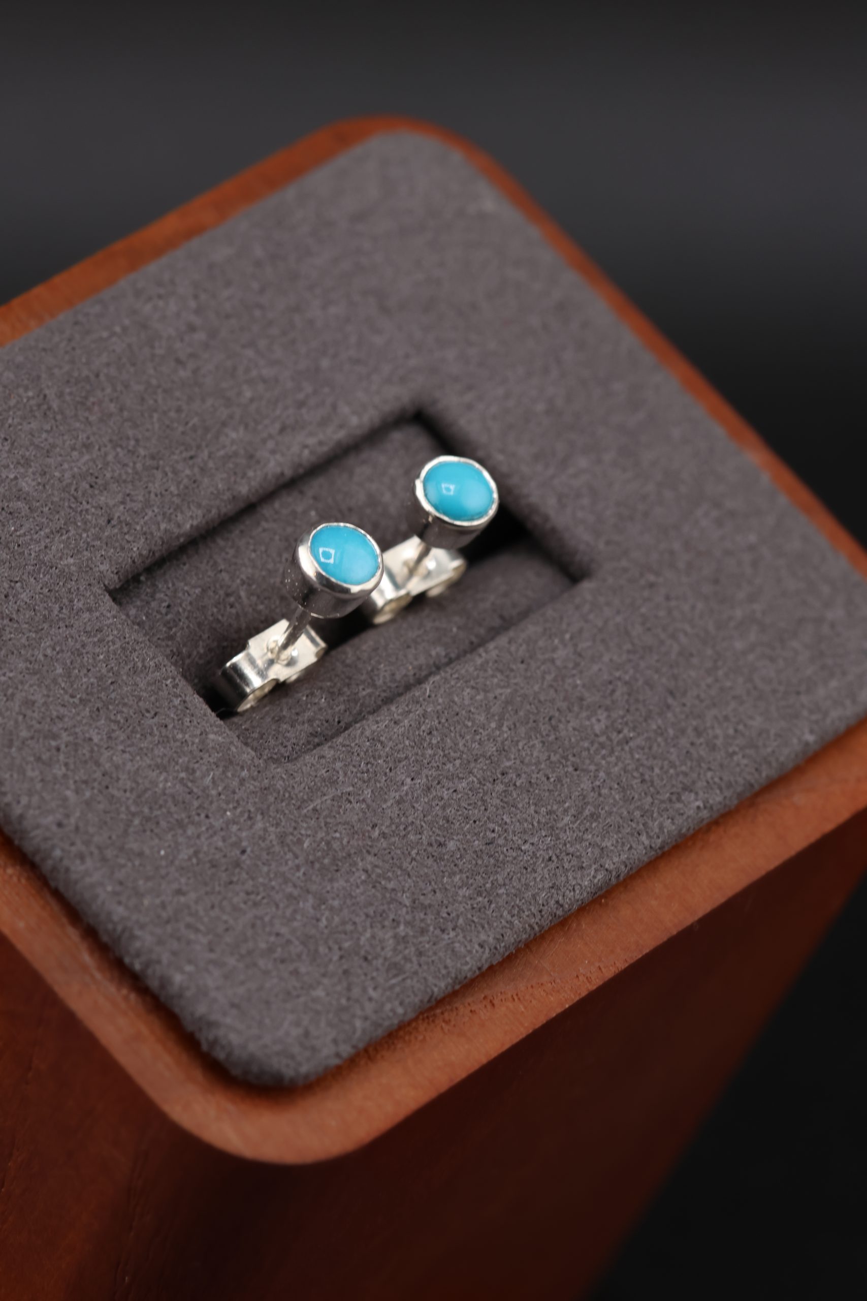 9E2A2988 Turquoise stud earrings in sterling silver. Handmade in Devon, by award winning goldsmith jeweller James French at JWF Unique Designs. The Turquoise stones are flush set into the stud earrings and come with sterling silver butterfly backs. The perfect gift, handmade jewellery.