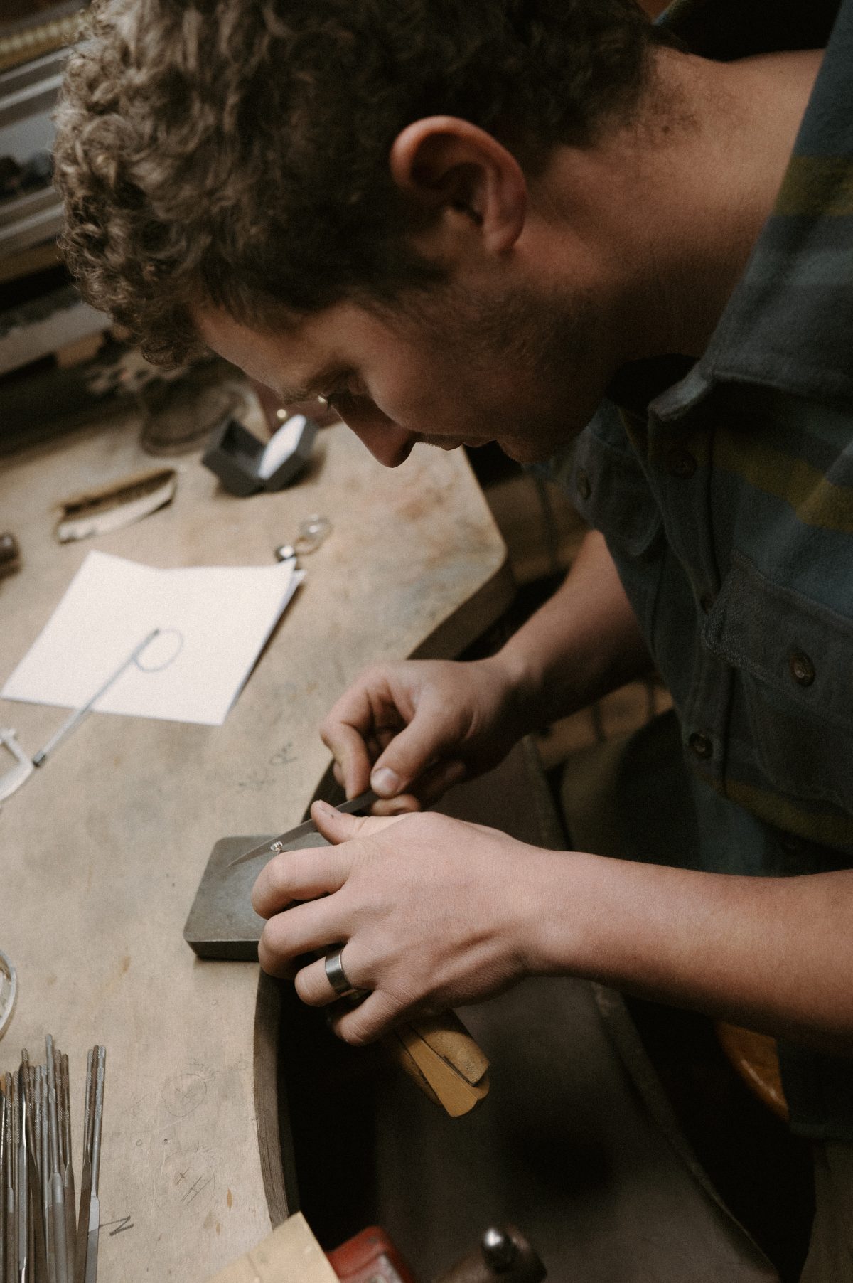 Titanium wedding ring being worn at the workbench. Handmade titanium rings.