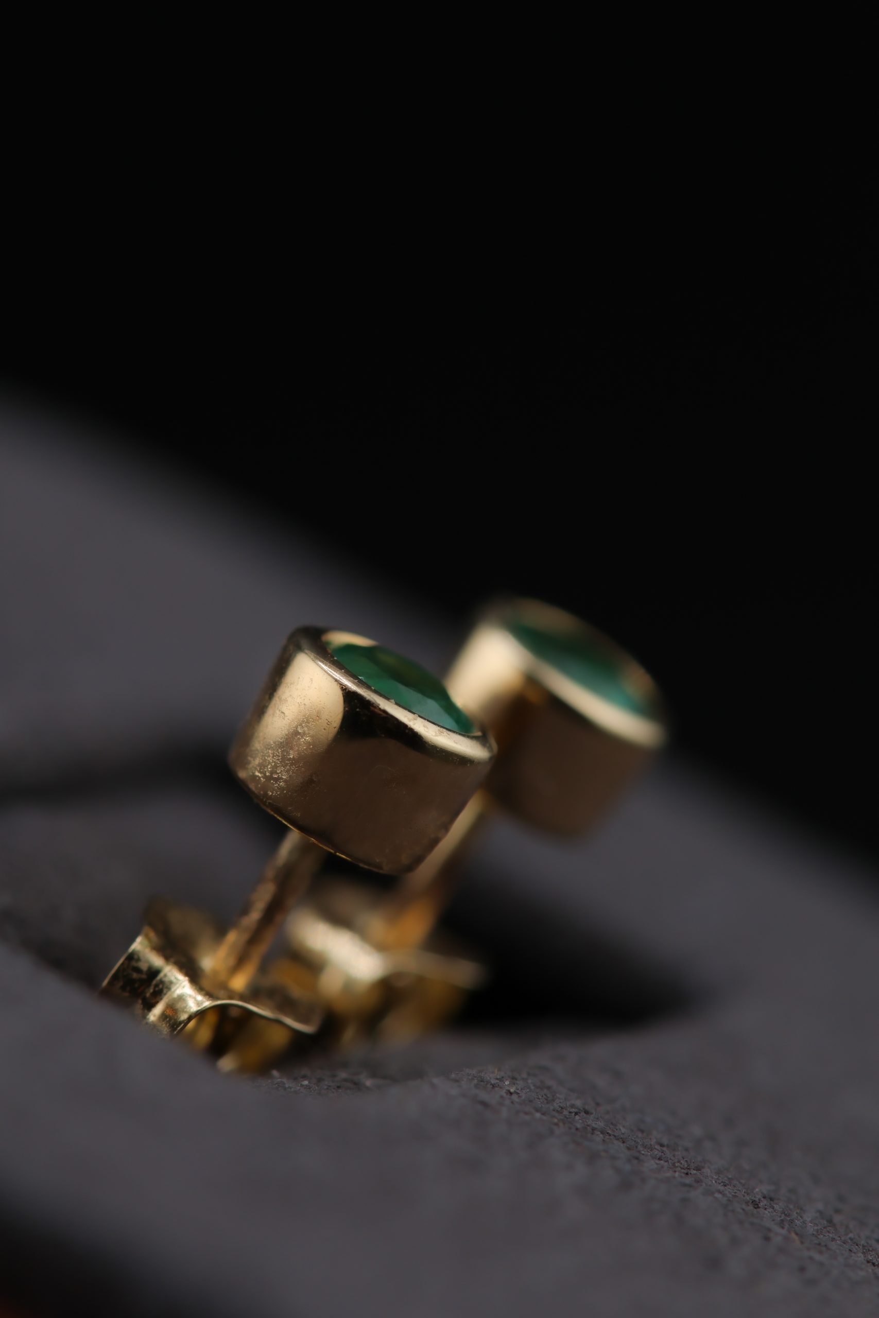 9E2A2323 Yellow gold emerald stud earrings. Designed and handcrafted by James French at JWF Unique Designs, in Devon, UK. The emerald stones are approximately 3.5mm in width and are in a bezel flush setting into 9ct and 18ct yellow gold. They are secured with yellow gold bitterly backs for security. These emerald stud earrings are timeless and classic and are an easy day wear. A brilliant gift for a loved one.