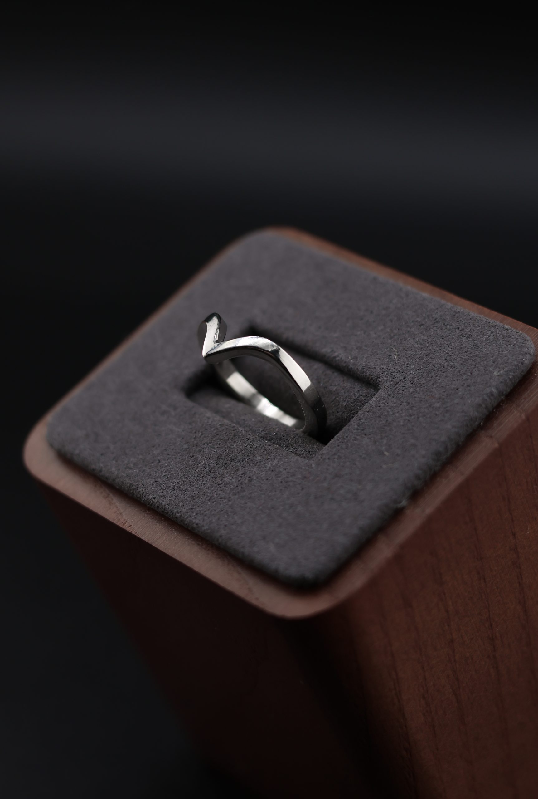 9E2A3612 1.65mm chevron wedding ring with a shaped V profile. Designed to sit neatly against an engagement ring. Slim, precise, and easy to wear. Available in sterling silver, white gold, and platinum. Ideal for women wanting a shaped wedding ring that follows the line of their engagement ring. Handmade in Devon, UK. Crafted by award-winning goldsmith James French at JWF Unique Designs.