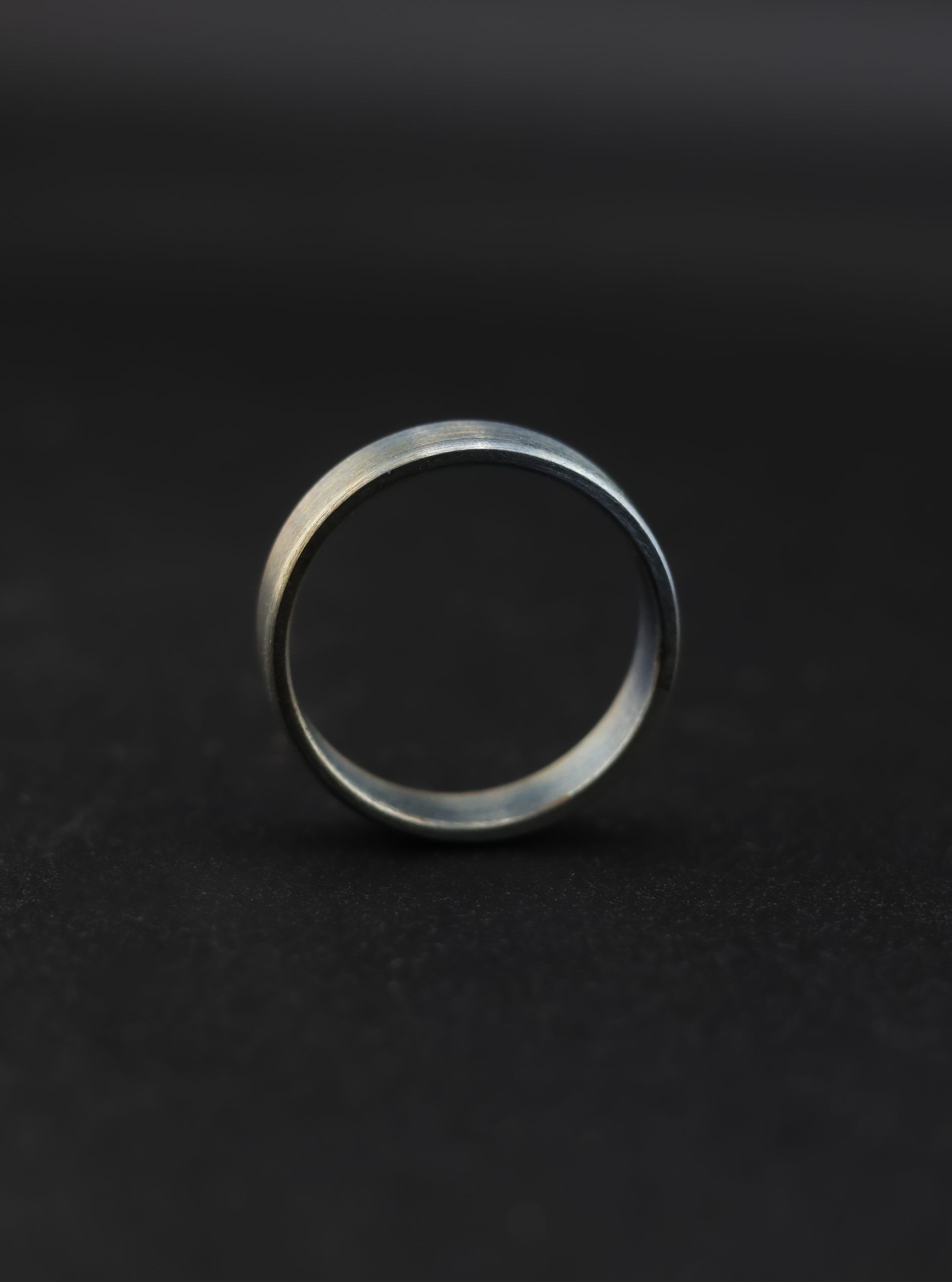 9E2A3652 Anodised titanium wedding ring with flat profile. Subtle colour variation created through anodising. Each ring has a unique finish. Lightweight and durable titanium band. Handmade in Devon, UK.