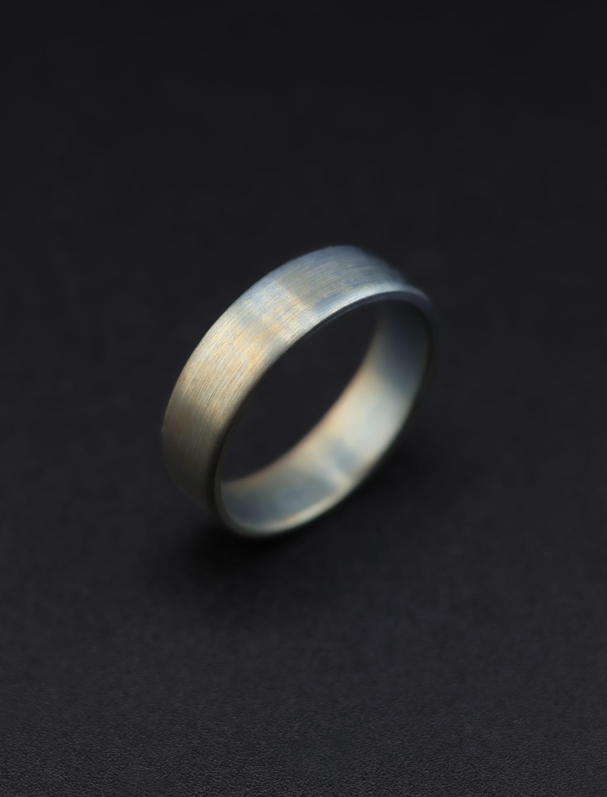 9E2A3654-2 Anodised titanium wedding ring with flat profile. Subtle colour variation created through anodising. Each ring has a unique finish. Lightweight and durable titanium band. Handmade in Devon, UK.