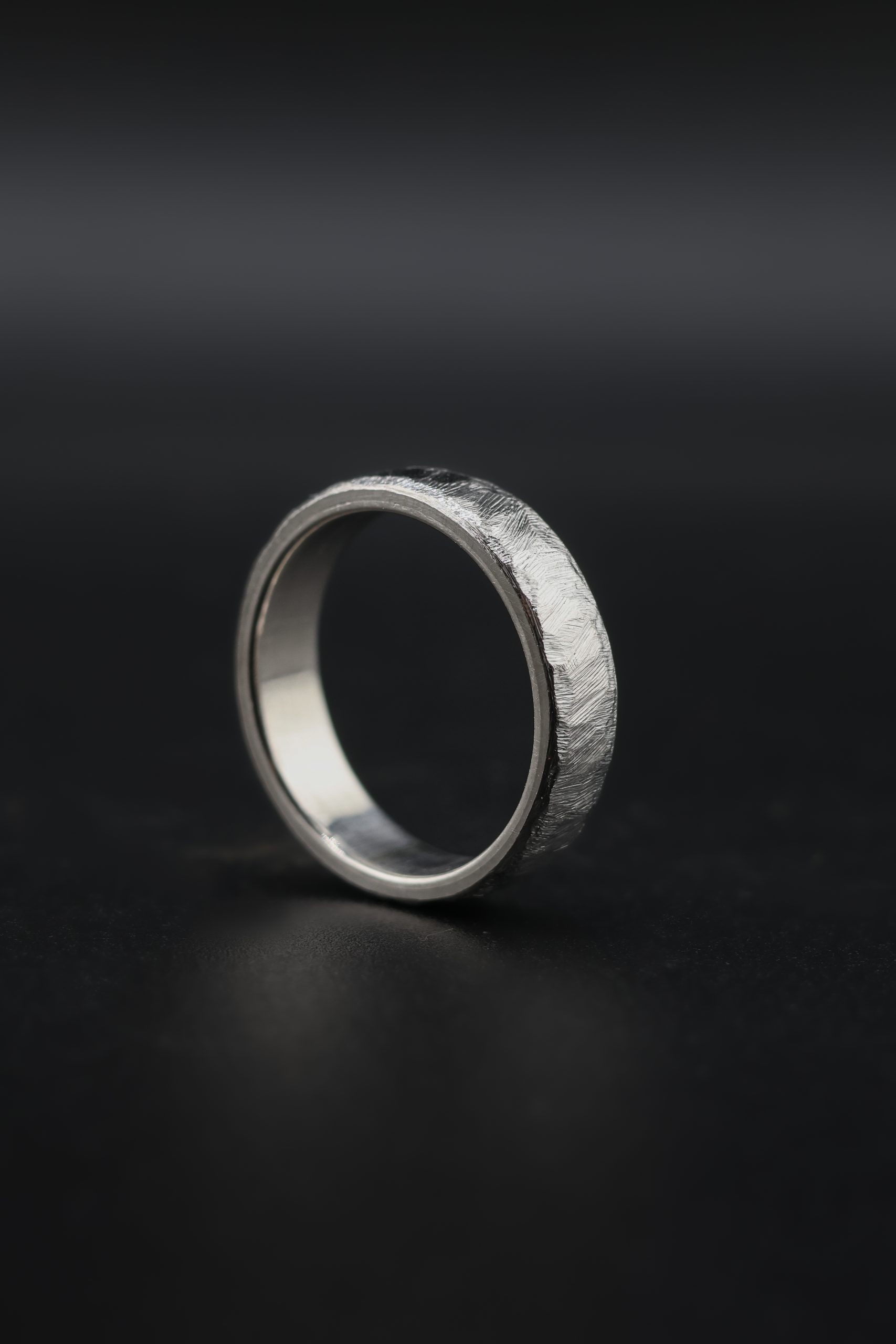 9E2A4319 Titanium wedding ring with cast texture and platinum liner. Slightly rounded profile with organic textured surface. 6mm wide. Lightweight and durable wedding ring. Handmade in Devon, UK by award-winning goldsmith James French.
