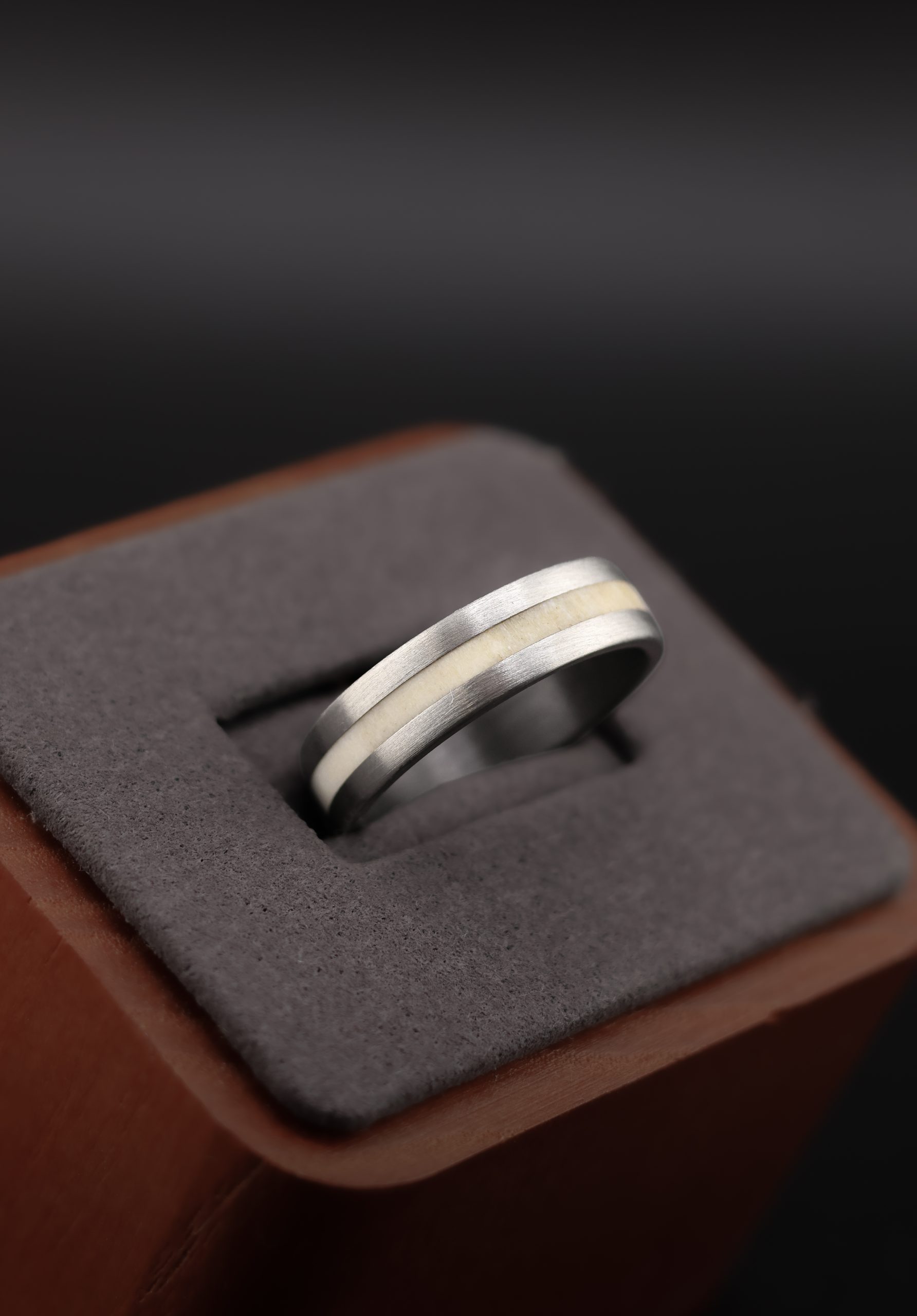 9E2A4421 Titanium wedding ring with natural deer antler inlay. 6mm width, flat profile with rounded corners. Handmade in the UK by award winning jeweller James French. Perfect for a unique and durable wedding ring