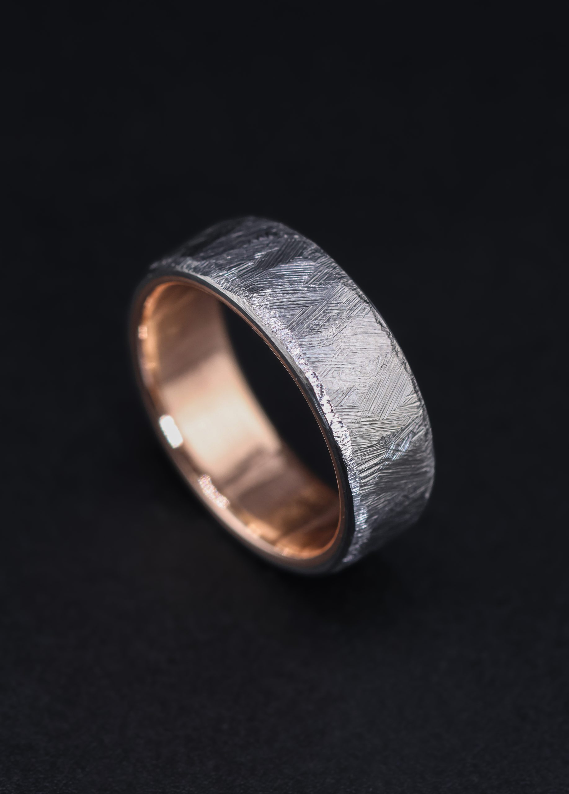 9E2A5845 A men’s titanium wedding ring with a textured cast finish, flat profile and solid 9ct rose gold liner. This 7mm titanium wedding ring is lightweight, durable and handmade by James French at JWF Unique Designs in Devon.