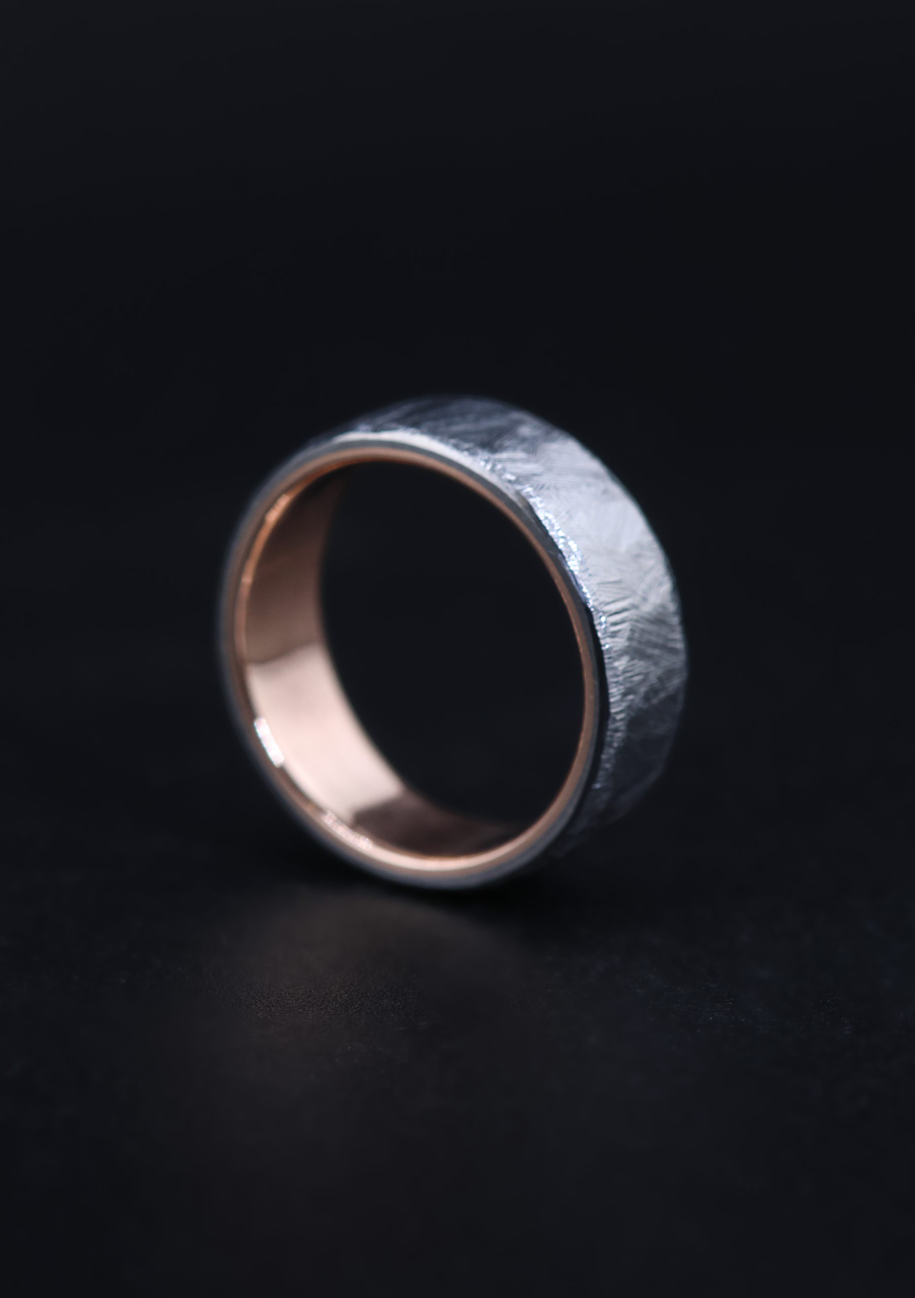 9E2A5849 A men’s titanium wedding ring with a textured cast finish, flat profile and solid 9ct rose gold liner. This 7mm titanium wedding ring is lightweight, durable and handmade by James French at JWF Unique Designs in Devon.
